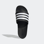 Black slide sandal with white stripes on a light gray background