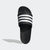 Black slide sandal with white stripes on a light gray background