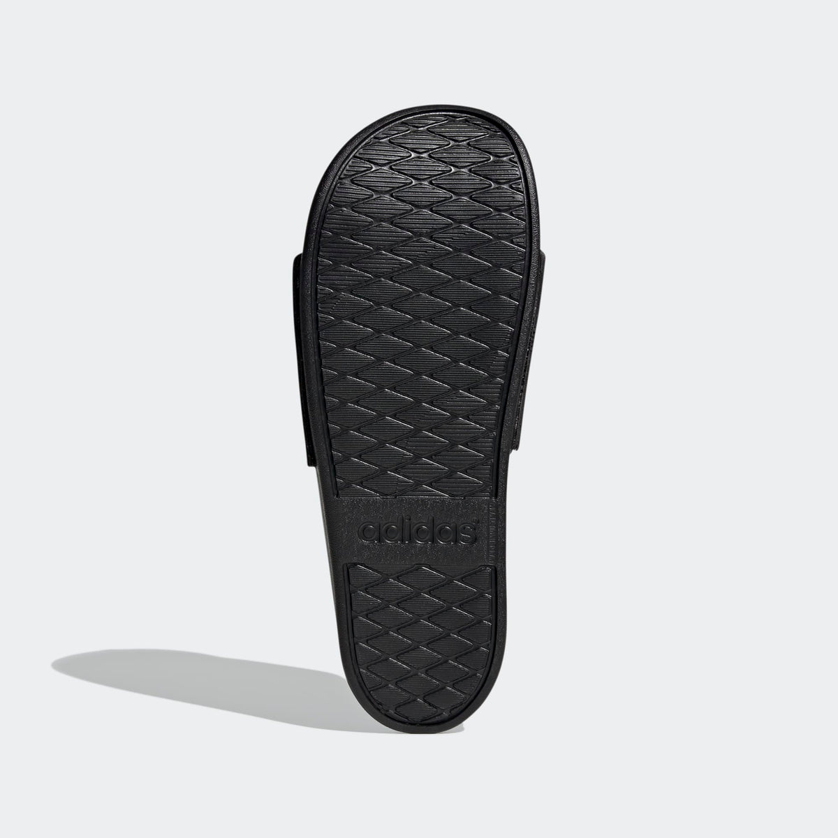 Black Adidas slide sandal on a light gray background
