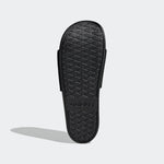 Black Adidas slide sandal on a light gray background
