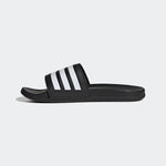 Black slide sandal with white stripes on a light gray background